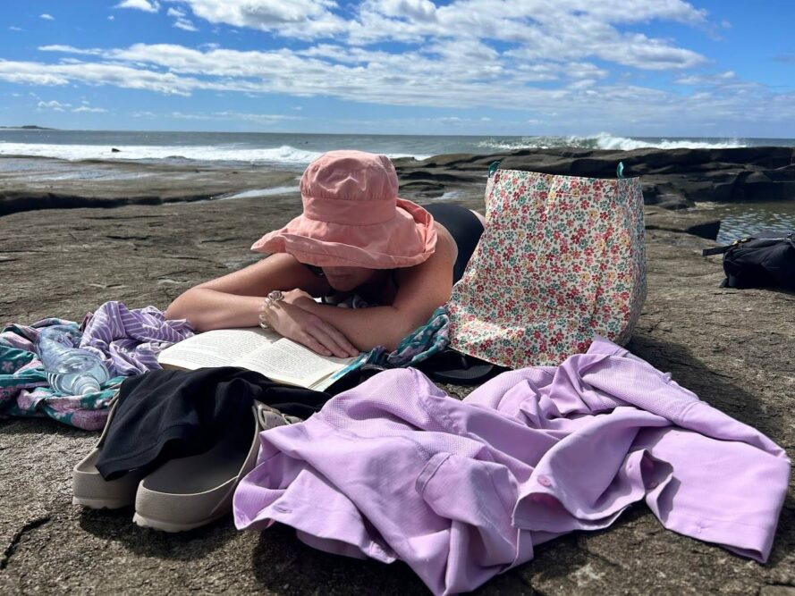 Angourie-Blue-Pool-Yamba-NSW-reading-on-a-rock-Travellarks - Travellarks Angourie-Blue-Pool-Yamba-NSW-reading-on-a-rock-Travellarks