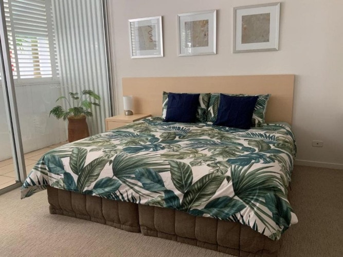 Bedroom with tropical quilt and louvered shutters at Jemingars Place, Rainbow Beach QLD accommodation