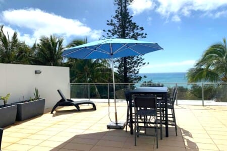 Balcony dining with umbrella at Jemingars Place, Rainbow Beach QLD accommodation