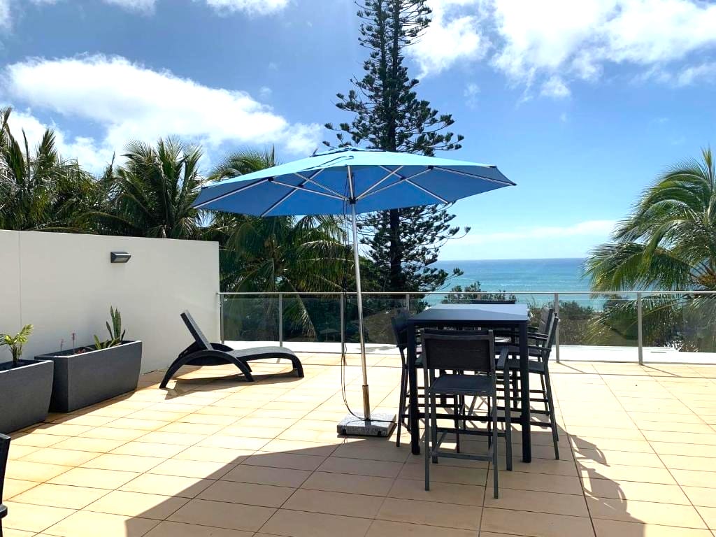Balcony dining with umbrella at Jemingar's Place, Rainbow Beach QLD accommodation