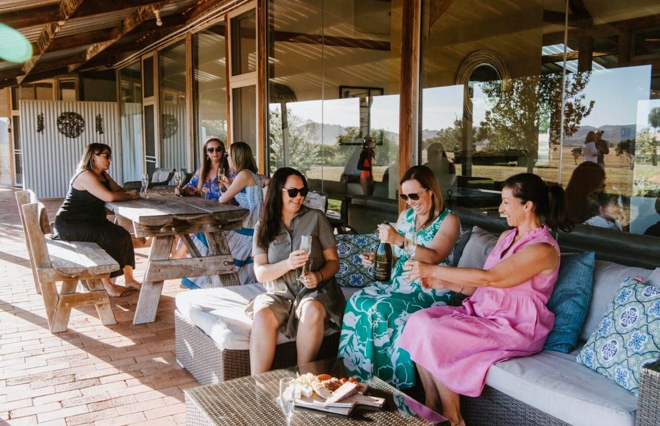 Owlheadlodgegulgongglasscottageaccommodationnsw  Travellarks Getaways Group of women enjoying wine and laughter at Owl Head Lodge Gulgong a stylish country accommodation listed with Travellarks Getaways